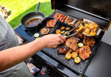 Adam arka bahçede ızgara ızgara yapıyor. Bbq partisi.