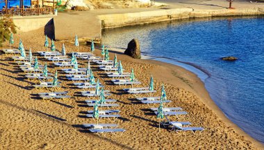 Empty beach chairs on sandy beach at reosrt Panormos in Crete island, Greece.