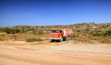 ELAFONISI, GREECE - SEPTEMBER 10, 2013: Old fire fighting truck parked in desert