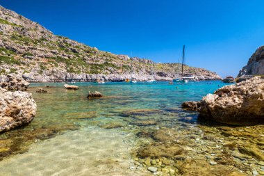 FALIRAKI, GREECE - JULY 4, 2022:Crystal clear sea with turquoise water in Anthony Quinn bay in Rhodes island in Greece