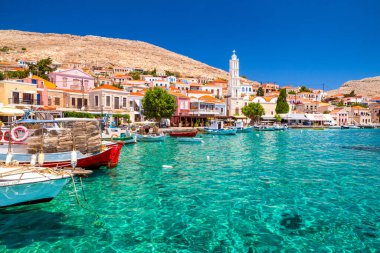 Halki, Yunanistan - 6 Temmuz 2022: Yunanistan 'ın pitoresk küçük adasındaki renkli evler ve balıkçı tekneleri Halki (Chalki)