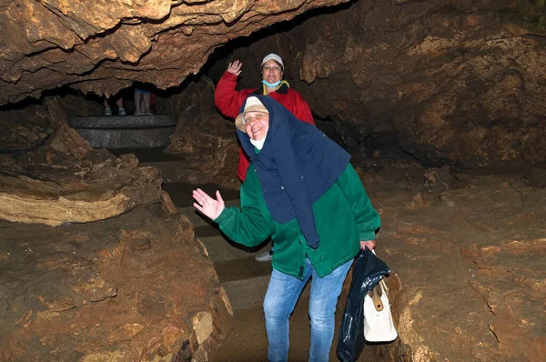 Two women, members of the tourist group, pose against the backdrop of the cave.