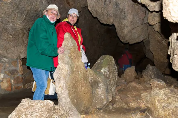 Two women, members of the tourist group, pose against the backdrop of the cave.