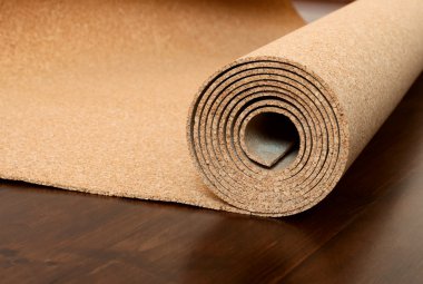 Roll of cork lies on a brown floor clipart