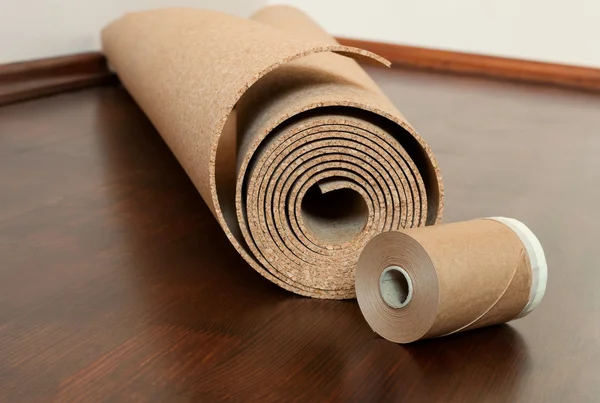 Rulla av kork med målning kantning tejp på ett brunt golv — Stockfoto