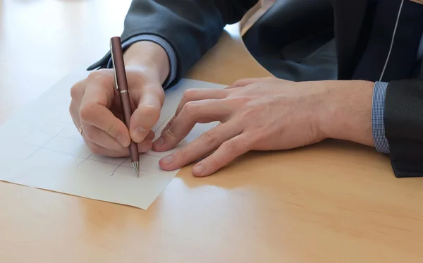 Der Mensch schreibt etwas auf ein weißes Papier. Büroarbeit — Stockfoto