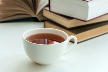 fincan siyah çay ve masanın üzerinde yatan bir kitap