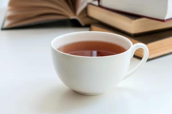 Tasse schwarzen Tee und ein paar Bücher zum Lesen liegen auf dem Tisch — Stockfoto