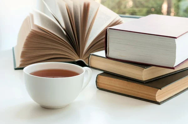 Filiżankę czarnej herbaty i kilka książek do przeczytania, leżący na stole — Zdjęcie stockowe