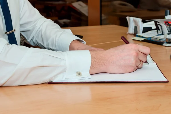 L'homme écrit quelque chose sur un livre blanc. Travaux de bureau — Photo