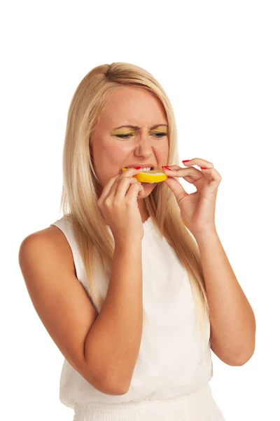 Girl eating lemon with displeasure — Stock Photo, Image