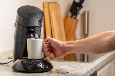 Erkek el kahve makinesinden taze kahve alıyor. 