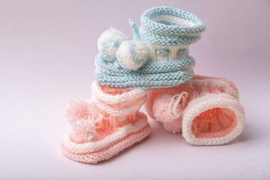 Beyaz arka planda yeni doğan erkek ve kızlar için ev yapımı örgü ayakkabılar.