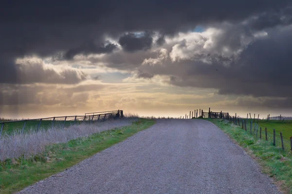 Сільська дорога веде до вражаючого хмарного пейзажу — стокове фото