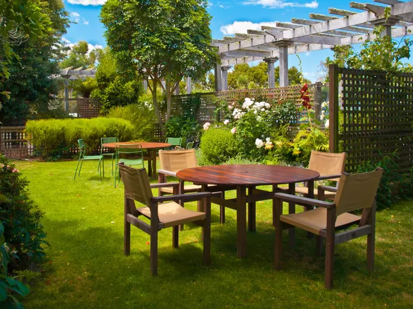 Dining table set in lush garden — Stock Photo, Image