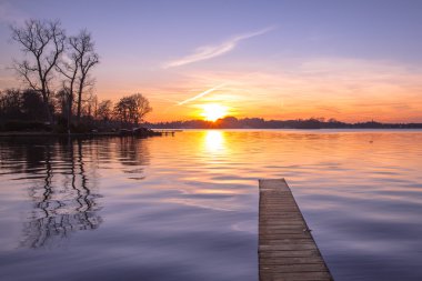 Mor günbatımı üzerinde ahşap iskelesi Groningen, Hollanda
