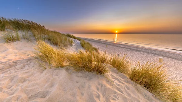 Sunset View over ocean from dune over North Sea and Canal in Ouddorp, Zeeland Province, the Netherlands. Outdoor scene of coast in nature of Europe.