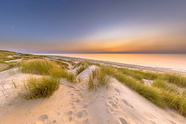 Sunset View over ocean from dune over North Sea and Canal in Ouddorp, Zeeland Province, the Netherlands. Outdoor scene of coast in nature of Europe.