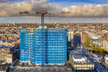 Hollanda 'nın Groningen kentindeki yüksek katlı bina inşaat vinç manzaralı.