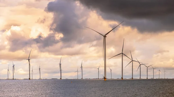 洋上ウィンドファーム 曇り空の下でIjselmeerの水の中の風力タービンのグループ 風力エネルギーは グリーン電力の持続可能性への移行において最も安価な形態の1つとなっている オランダ — ストック写真