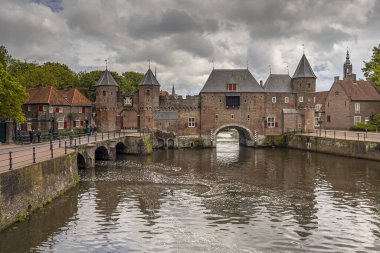 Amersfoort, Hollanda 'daki Koppelpoort' a tarihi arazi ve su baskını. Bulutlu gökyüzünün altındaki tarihi güçlendirilmiş şehir kapısı.