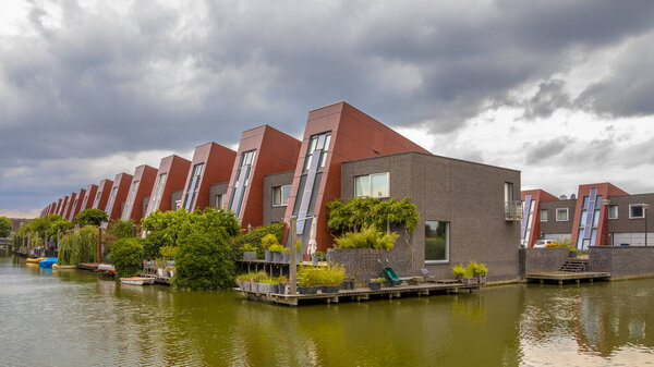 Экологические дома со встроенными солнечными панелями и висячими садами на набережной в городской зоне Хаге, Нидерланды
