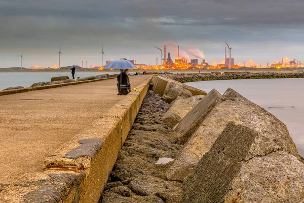 在一个阴天的下午 在Ijmuiden附近的混凝土防波堤与垂钓者在一个阴云密布的下午和沉重的工业背景 荷兰北荷兰省 — 图库照片