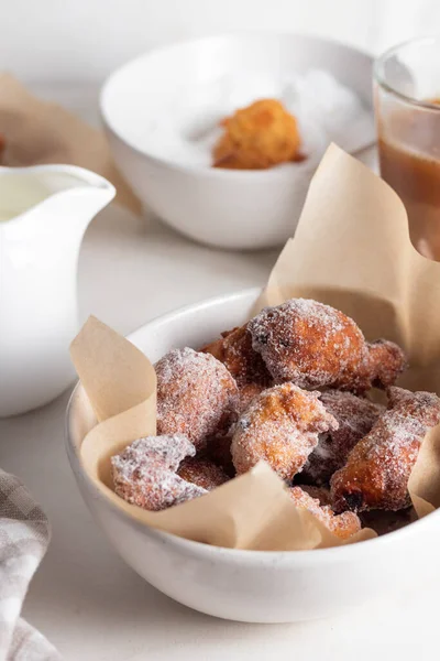 Ev yapımı muzlu donut topları ve hafif arka planda bir kasede pudra şekeri. Güzel kahvaltı..