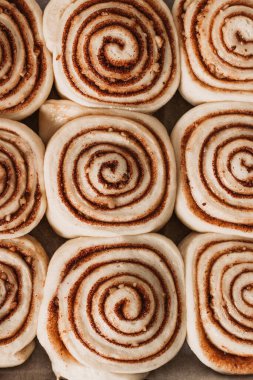 Tarçınlı rulo ev yapımı hamur hazırlama. Geleneksel tarçınlı tatlı çörekleri kıvrıldı. Metin için arka plan. Ev yapımı pişirme. Üst görünüm.