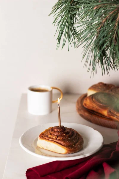 Yeni pişirilmiş ev yapımı tarçınlı rulo ya da Noel için mumlu tarçınlı tarçın. Tatil atmosferi. Cinnabon. Metin için arkaplan. 