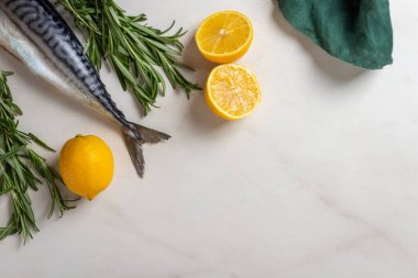 Tahta üzerinde limonlu, biberiyeli, tuzlu ve pembe biberli taze balık ve parşömen.. 