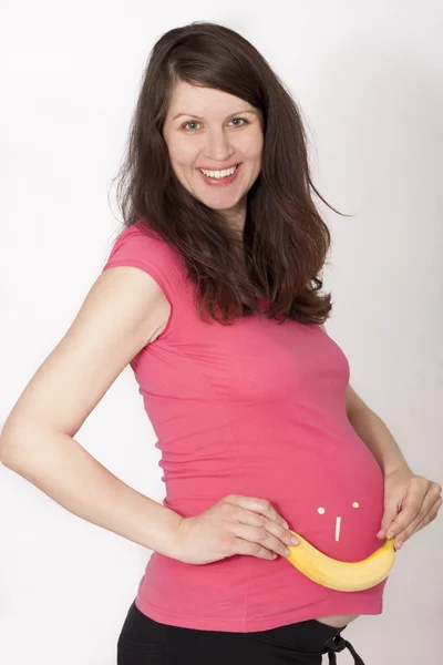 Glimlachend zwangere vrouw met banaan glimlachen gezicht — Stockfoto