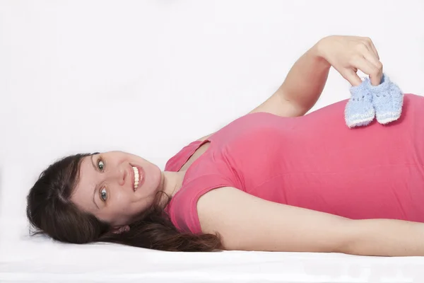 Pregnant woman holding baby slippers — Stock Photo, Image