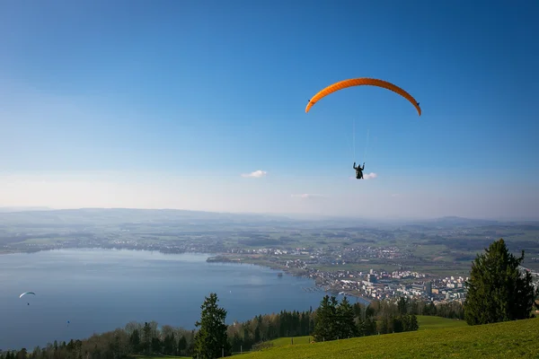 Yamaçparaşütü sırasında hava güneşli ve açık mavi gökyüzü zug city, zugersee ve İsviçre Alpleri üzerinde