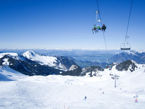 Skiers skiing in Klewenalp ski resort with view to Lucerne lake, Central Switzerland — Stock Photo, Image