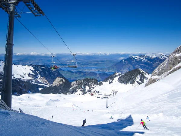 Esquiadores esquiando en Klewenalp estación de esquí con vistas al lago de Lucerna, Suiza Central —  Fotos de Stock