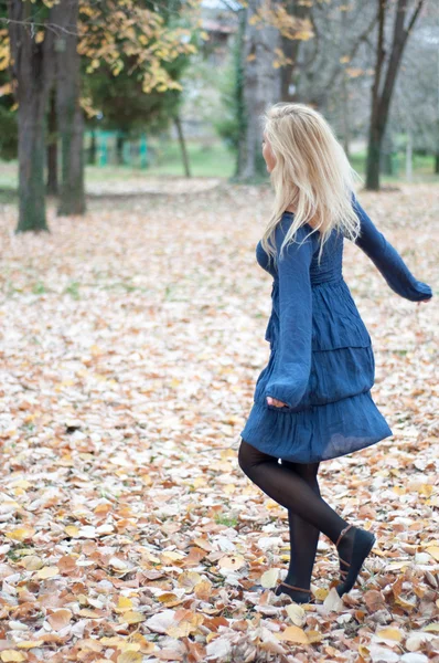 Menina bonita dança no parque no outono — Fotografia de Stock