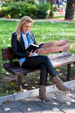 Parkta kitabı olan bir kız.