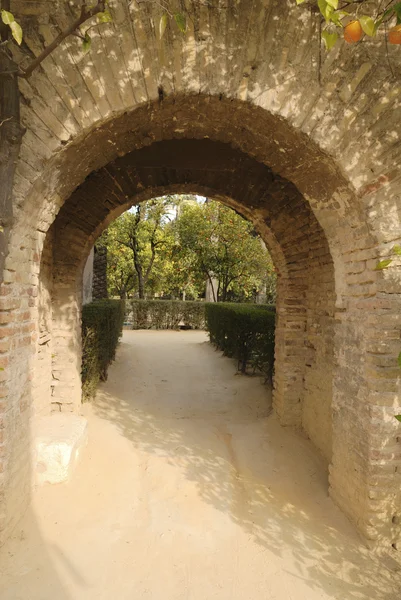 Arco de tijolo nos jardins do Alcazar de Sevilha, Espanha — Fotografia de Stock