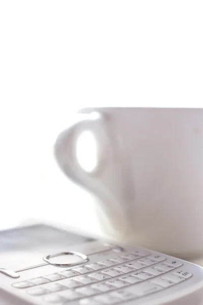 kahve fincanı ve beyaz zemin üzerine telefon