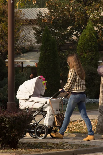 bir bebek arabası ile yürüyen kadın