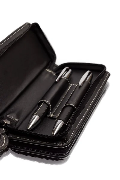 beyaz zemin üzerinde bir deri çanta içinde kalem ve kurşun kalem