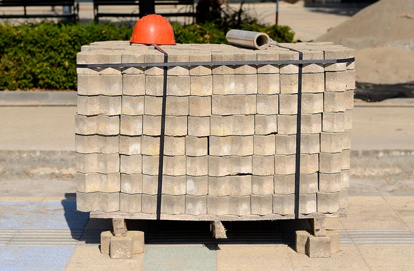 Heap of paving stone and helmet in city construction — Stock Photo, Image