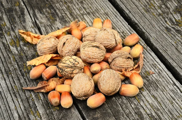 Valnötter och hasselnötter på trä bakgrund — Stockfoto