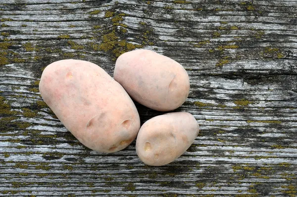 Pommes de terre sur un fond de bois rugueux — Photo