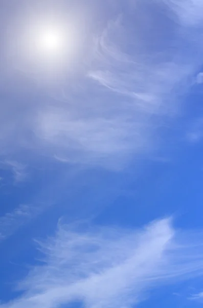 Wolken op een blauwe lucht met zon — Stockfoto