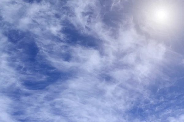 Wolken op een blauwe lucht met zon — Stockfoto