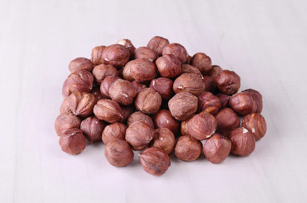 Pile hazelnuts on wooden background — Stock Photo, Image