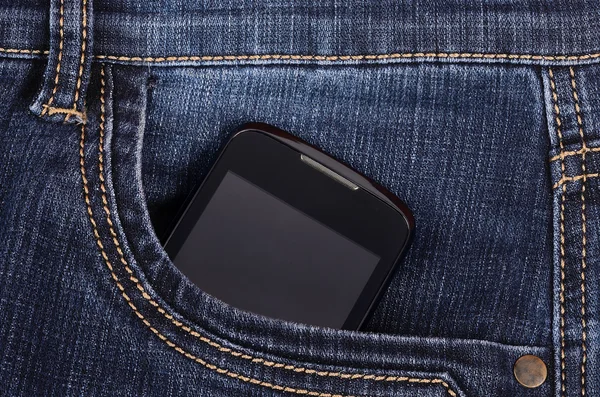Parte del teléfono celular en el bolsillo de los vaqueros azules — Foto de Stock
