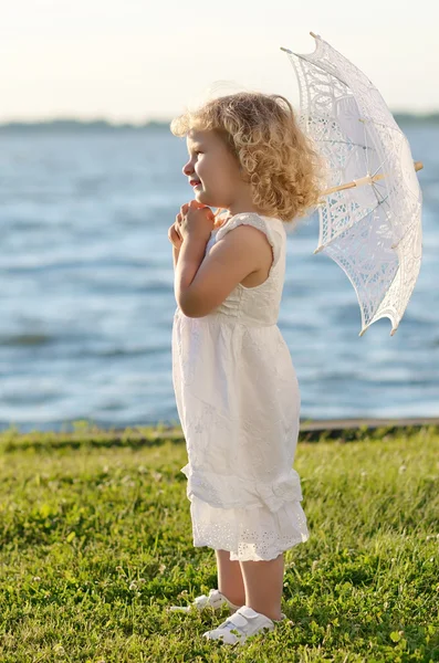 Молодая красивая девушка позирует перед камерой в белом платье — стоковое фото